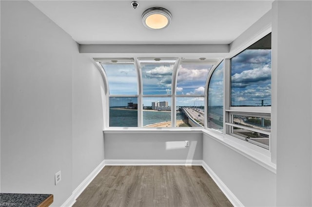 3556 Shore Dr Unit 704, Virginia Beach, VA 23455 - unfurnished room with wood finished floors, fire sprinkler in ceiling, a water view, and baseboards