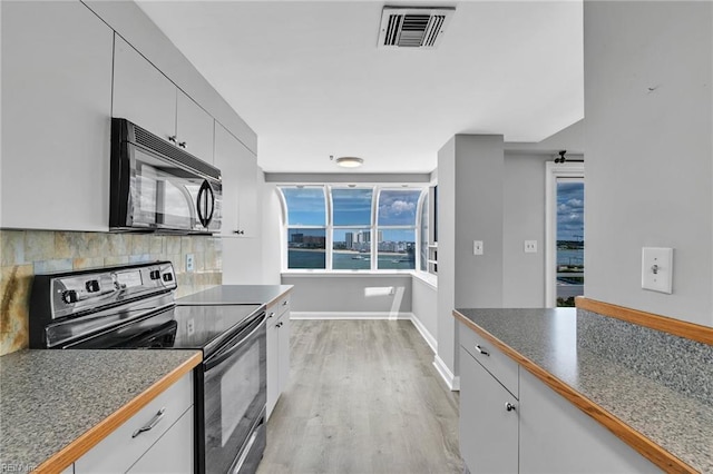 3556 Shore Dr Unit 704, Virginia Beach, VA 23455 - kitchen with black appliances, baseboards, tasteful backsplash, light wood-type flooring, and dark countertops