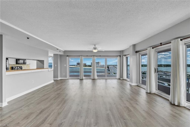 3556 Shore Dr Unit 704, Virginia Beach, VA 23455 - unfurnished living room with a textured ceiling, wood finished floors, ceiling fan, and baseboards