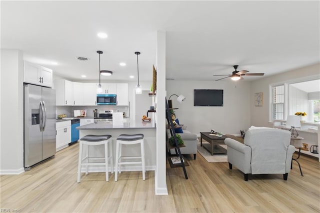 4009 Forresthills Dr, Portsmouth, VA 23703 - kitchen featuring appliances with stainless steel finishes, light wood finished floors, white cabinets, a peninsula, and recessed lighting