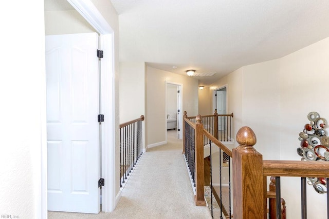 corridor featuring an upstairs landing, light colored carpet, and baseboards