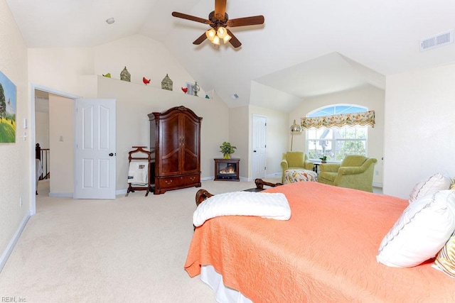 bedroom with lofted ceiling, carpet floors, a ceiling fan, baseboards, and a glass covered fireplace