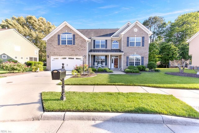 view of front of house featuring driveway, an attached garage, brick siding, and a front yard