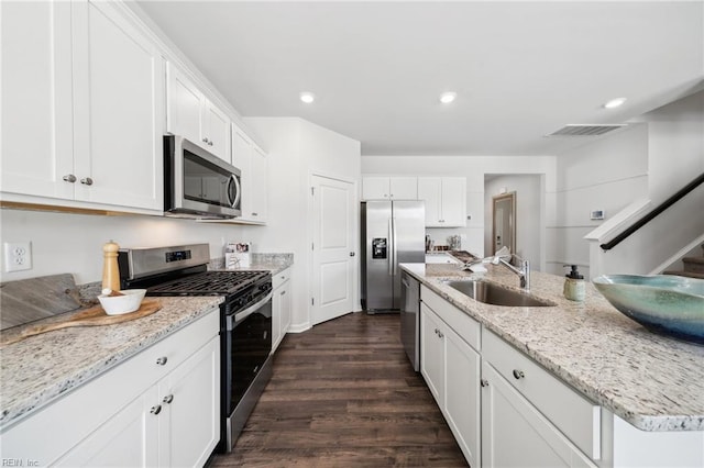 3019 Dalton Cir, Suffolk, VA 23435 - kitchen with appliances with stainless steel finishes, a sink, dark wood finished floors, white cabinets, and a center island with sink