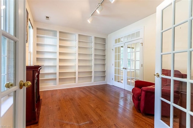 1209 Willow Creek Ct, Chesapeake, VA 23321 - living area featuring french doors, wood finished floors, built in shelves, and rail lighting