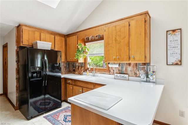 3408 Waterview Rd, Toano, VA 23168 - kitchen with black fridge with ice dispenser, a sink, a peninsula, vaulted ceiling, and tasteful backsplash