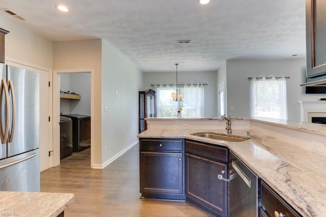 2825 Ridgeboard Pl, Chesapeake, VA 23323 - kitchen featuring appliances with stainless steel finishes, a sink, independent washer and dryer, wood finished floors, and light stone counters