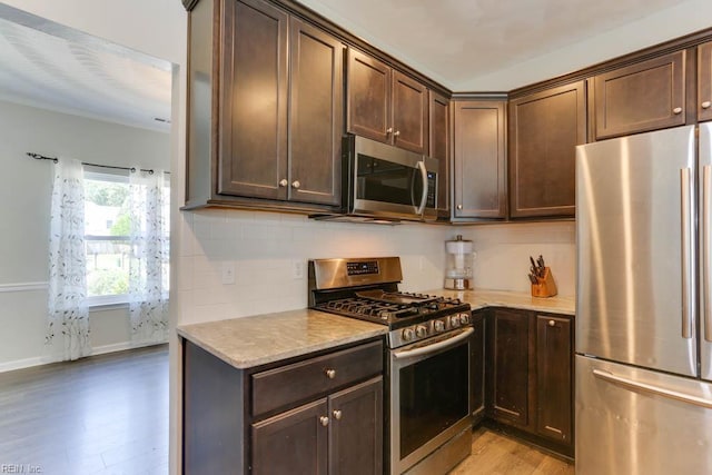 2825 Ridgeboard Pl, Chesapeake, VA 23323 - kitchen with stainless steel appliances, light wood finished floors, dark brown cabinets, and light stone counters