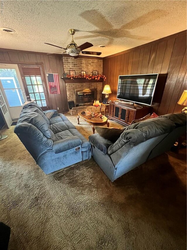 5113 Stratford Chase Dr, Virginia Beach, VA 23464 - carpeted living room featuring wooden walls, a textured ceiling, a ceiling fan, and a brick fireplace