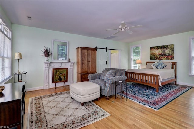 117 Shinnecock, Williamsburg, VA 23188 - bedroom featuring wood finished floors, a barn door, baseboards, and a fireplace