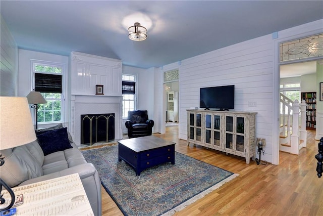 117 Shinnecock, Williamsburg, VA 23188 - living area with a fireplace, healthy amount of natural light, light wood-style floors, and wooden walls