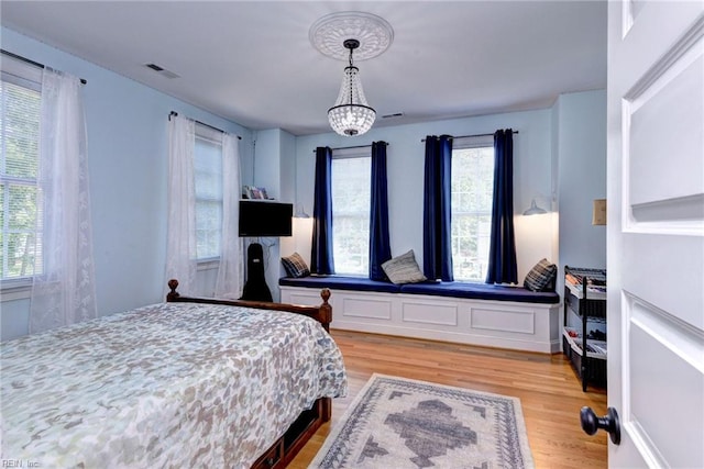117 Shinnecock, Williamsburg, VA 23188 - bedroom with light wood-style flooring, multiple windows, and a chandelier