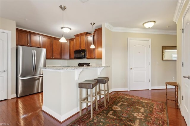 5414 Foundation St, Williamsburg, VA 23188 - kitchen with freestanding refrigerator, black microwave, a kitchen breakfast bar, dark wood-type flooring, and ornamental molding