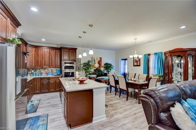 101 Utah St, Portsmouth, VA 23701 - kitchen featuring stainless steel appliances, open floor plan, a chandelier, light wood-style floors, and tasteful backsplash