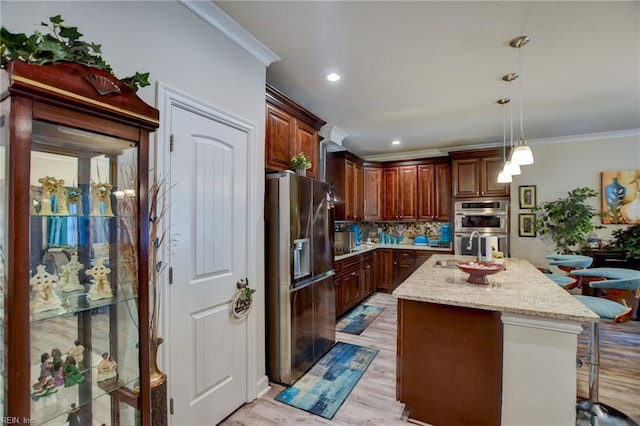 101 Utah St, Portsmouth, VA 23701 - kitchen featuring appliances with stainless steel finishes, crown molding, a kitchen island with sink, decorative light fixtures, and tasteful backsplash