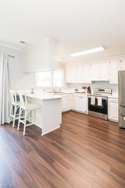 1 Lake Walk Xing, Hampton, VA 23666 - kitchen featuring stainless steel appliances, under cabinet range hood, white cabinetry, light countertops, and crown molding