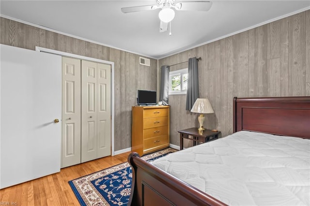 8332 Halprin Dr, Norfolk, VA 23518 - bedroom featuring a closet, wood finished floors, crown molding, a ceiling fan, and wooden walls
