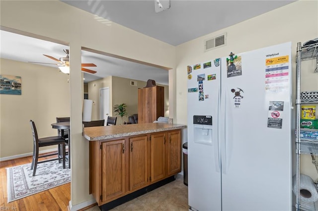 8332 Halprin Dr, Norfolk, VA 23518 - kitchen with white refrigerator with ice dispenser, a ceiling fan, brown cabinets, light wood-style flooring, and light countertops