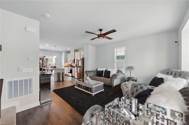 living room with ceiling fan and dark wood finished floors
