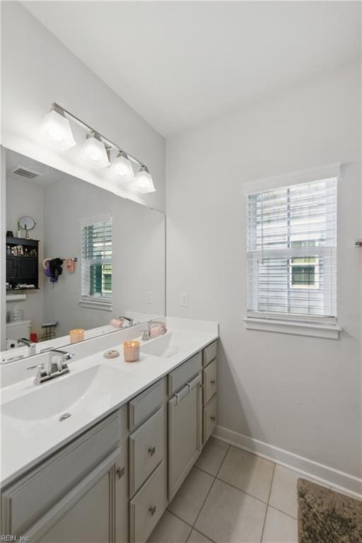 full bathroom featuring tile patterned flooring, double vanity, and baseboards