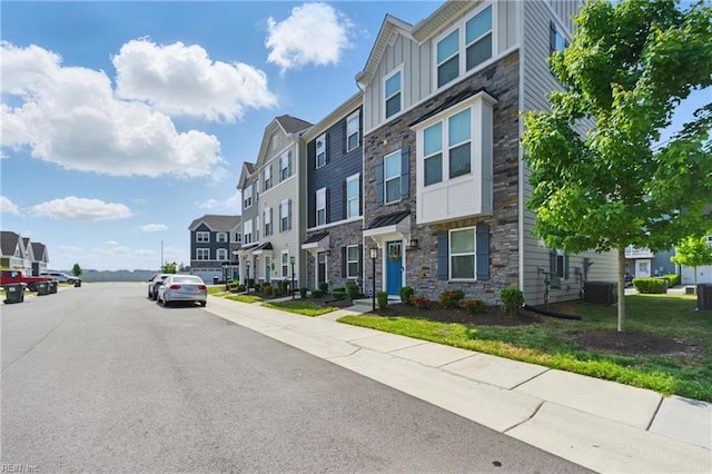 view of asphalt street with a residential view and sidewalks