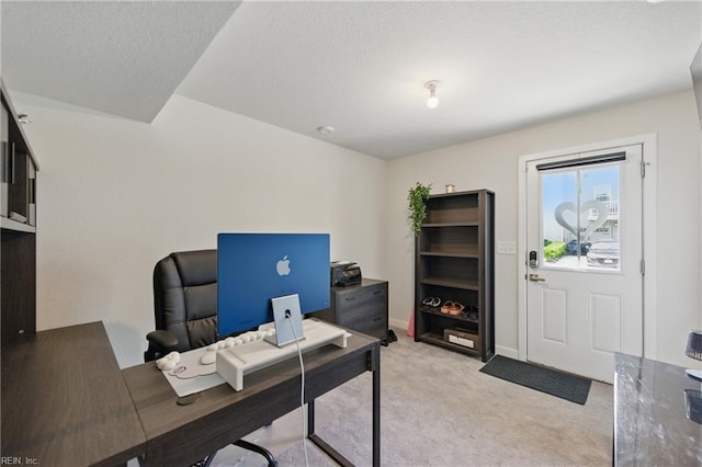 home office with light colored carpet, a textured ceiling, and baseboards
