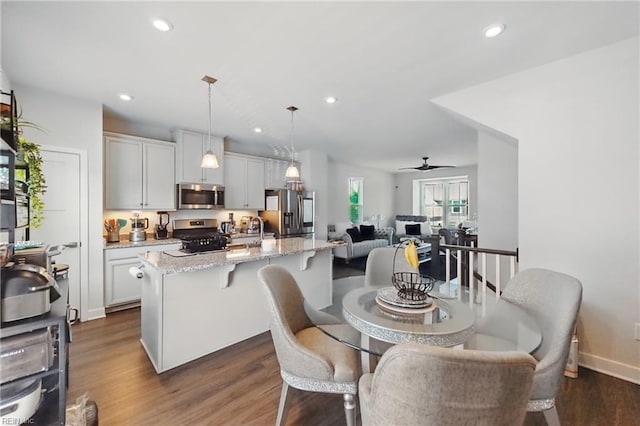 dining space featuring dark wood-type flooring, recessed lighting, ceiling fan, and baseboards