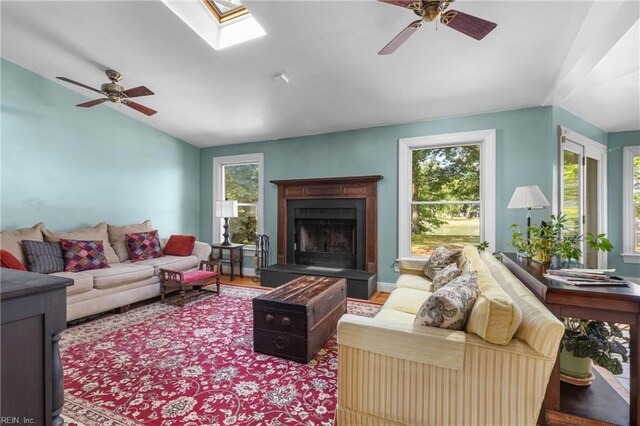 6052 Newport Cres, Norfolk, VA 23505 - living area featuring ceiling fan, lofted ceiling, a fireplace with raised hearth, wood finished floors, and a skylight