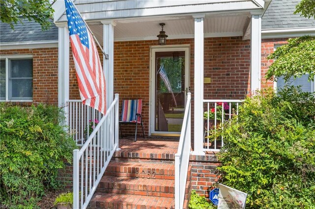6052 Newport Cres, Norfolk, VA 23505 - doorway to property featuring brick siding, a porch, and a shingled roof