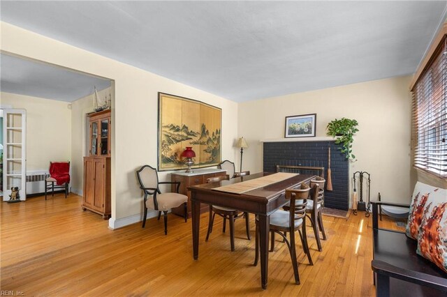 6052 Newport Cres, Norfolk, VA 23505 - dining room featuring a brick fireplace, light wood-style floors, and radiator heating unit