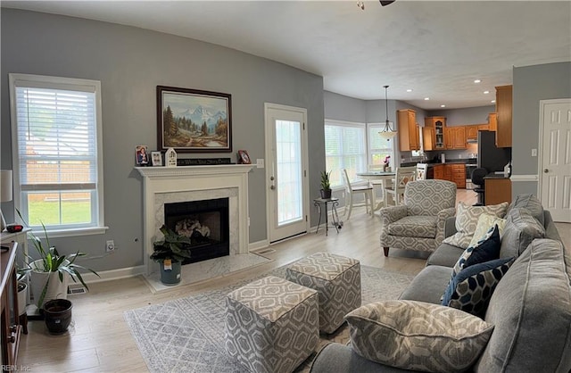 living area with healthy amount of natural light, light wood-style flooring, baseboards, and recessed lighting