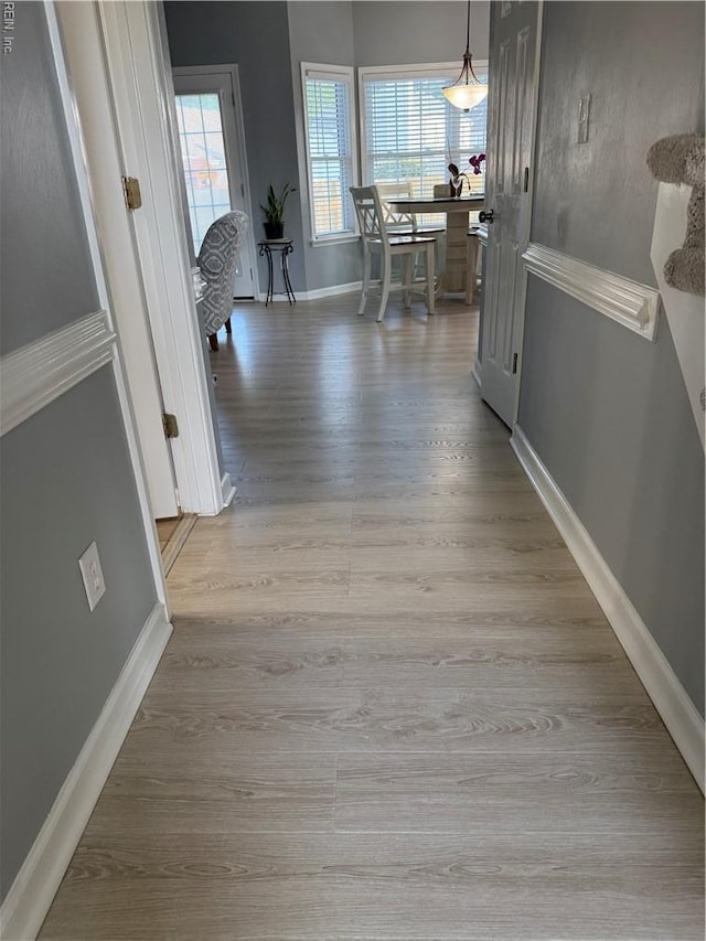 hallway with light wood-style flooring and baseboards