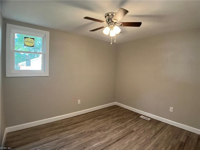 spare room featuring dark wood finished floors, baseboards, and a ceiling fan