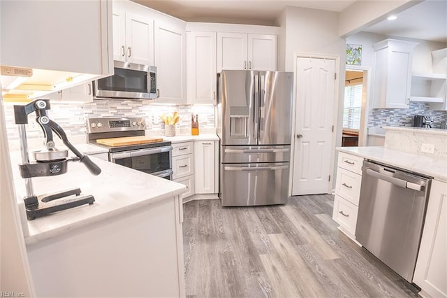 1660 Chestwood Dr, Virginia Beach, VA 23453 - kitchen with appliances with stainless steel finishes, white cabinets, light wood finished floors, decorative backsplash, and light stone counters