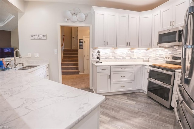 1660 Chestwood Dr, Virginia Beach, VA 23453 - kitchen with appliances with stainless steel finishes, a sink, light stone countertops, and white cabinetry