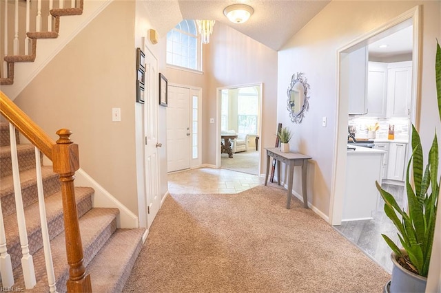 1660 Chestwood Dr, Virginia Beach, VA 23453 - entrance foyer featuring light carpet, stairs, vaulted ceiling, light tile patterned floors, and baseboards