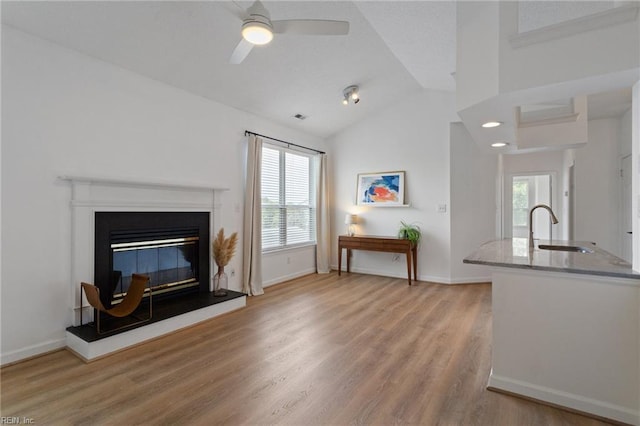 3200 Jade Ct Unit 301, Virginia Beach, VA 23451 - living room with light wood-type flooring, vaulted ceiling, a ceiling fan, a glass covered fireplace, and baseboards