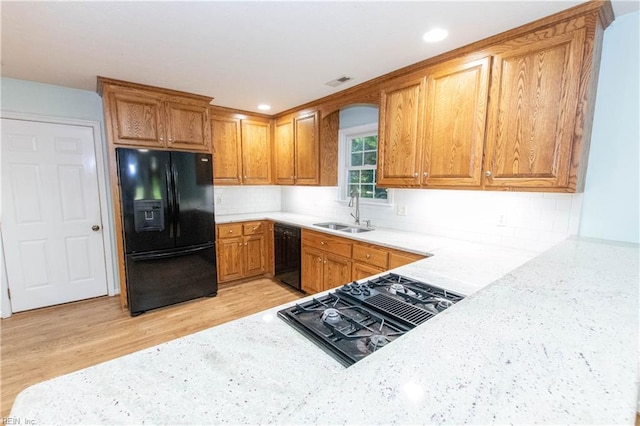 505 Plantation Rd, North, VA 23128 - kitchen with black appliances, a sink, brown cabinets, light wood-style floors, and decorative backsplash
