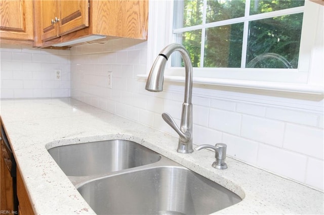 505 Plantation Rd, North, VA 23128 - kitchen view of a sink, brown cabinets, backsplash, and light stone counters