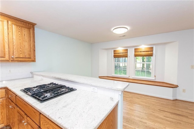 505 Plantation Rd, North, VA 23128 - kitchen with black gas stovetop, a peninsula, light wood finished floors, light stone counters, and decorative backsplash