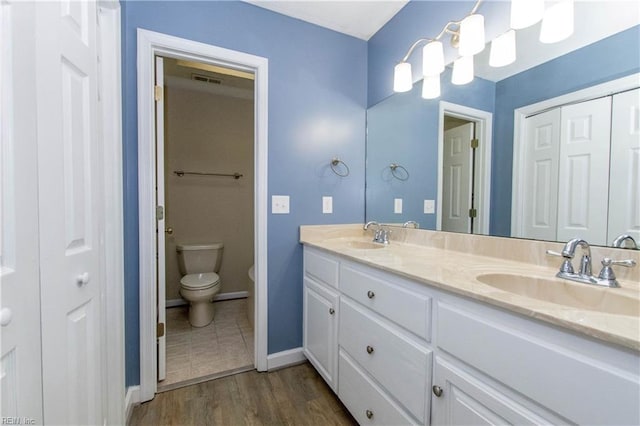 505 Plantation Rd, North, VA 23128 - bathroom featuring double vanity, toilet, wood finished floors, and baseboards