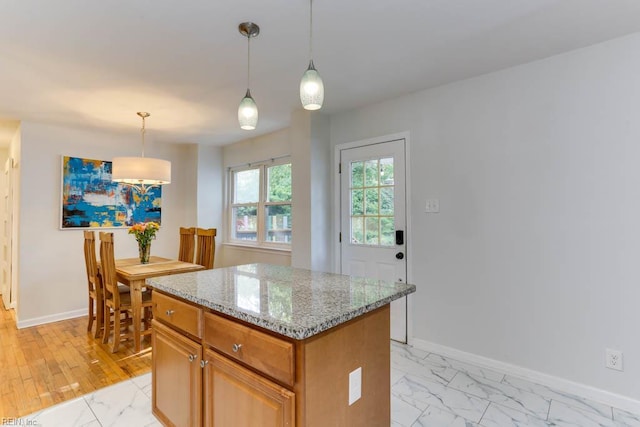 7811 Michael Dr, Norfolk, VA 23505 - kitchen with light marble finish floors, baseboards, a kitchen island, and light stone counters