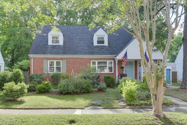 7811 Michael Dr, Norfolk, VA 23505 - cape cod-style house with brick siding, a front yard, and roof with shingles