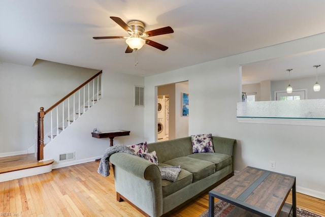 7811 Michael Dr, Norfolk, VA 23505 - living area with stacked washer / dryer, a ceiling fan, stairs, wood finished floors, and baseboards