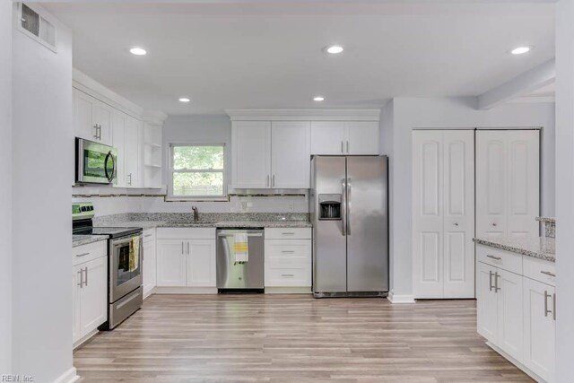541 Mango Dr, Virginia Beach, VA 23452 - kitchen with appliances with stainless steel finishes, a sink, white cabinetry, light wood-type flooring, and light stone counters