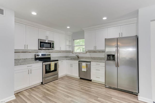 541 Mango Dr, Virginia Beach, VA 23452 - kitchen with appliances with stainless steel finishes, white cabinets, light stone countertops, light wood-style flooring, and a sink