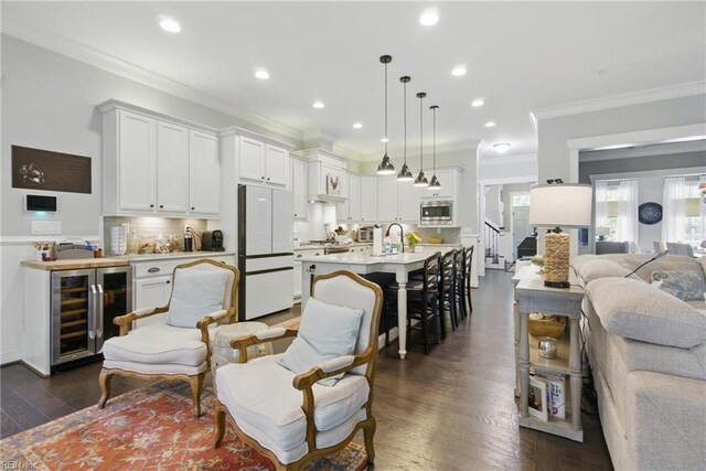 2408 Mathews Green Rd, Virginia Beach, VA 23456 - living area with wine cooler, crown molding, dark wood finished floors, a dry bar, and recessed lighting