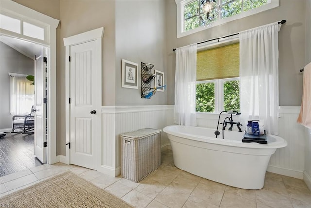 2408 Mathews Green Rd, Virginia Beach, VA 23456 - bathroom featuring plenty of natural light, a soaking tub, a wainscoted wall, tile patterned floors, and a chandelier