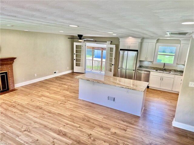 1813 Jack Frost Rd, Virginia Beach, VA 23455 - kitchen with stainless steel appliances, baseboards, a center island, white cabinets, and a sink