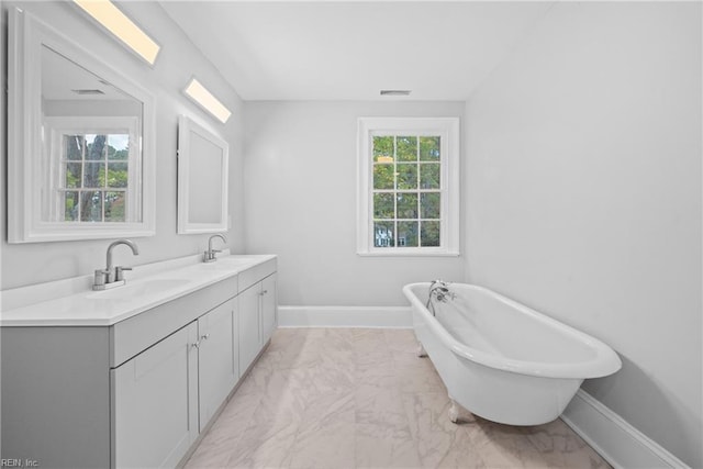 221 Homestead Rd, Franklin, VA 23851 - bathroom featuring marble look tile flooring, double vanity, a freestanding bath, and baseboards